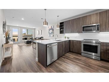 Modern kitchen with stainless steel appliances, wood cabinets, and white countertops, offering a sleek culinary space at 20 Wilcox St # 318, Castle Rock, CO 80104