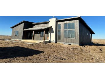 Newly constructed modern home featuring a large window and attractive two-tone exterior at 65960 E Evans Pl, Byers, CO 80103