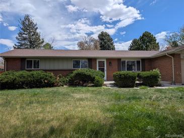 Charming single-story brick home featuring a well-manicured lawn and mature landscaping at 668 S Oakland St, Aurora, CO 80012