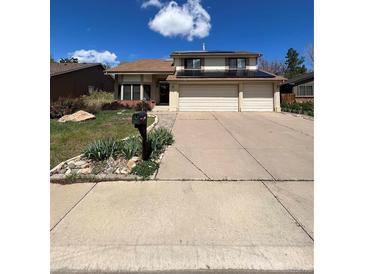 Charming two-story home featuring a three-car garage, well-manicured lawn, and installed solar panels at 15983 E Loyola Dr, Aurora, CO 80013