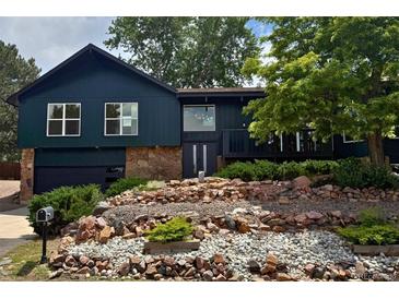 Charming multi-level home featuring stone accents, updated windows and a beautifully landscaped front yard at 14890 W 58Th Pl, Golden, CO 80403