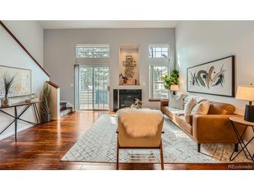 Bright living room with vaulted ceilings, wood floors, fireplace, and comfortable modern furniture at 1777 S Union Blvd, Lakewood, CO 80228