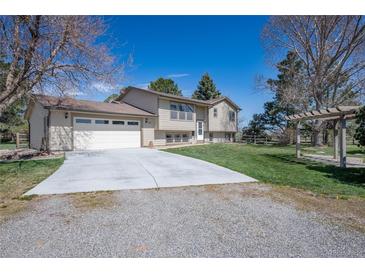 Inviting home with a large driveway, attached garage, and well-maintained front lawn at 2781 Savage Rd, Elizabeth, CO 80107