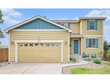 Charming home featuring a two-car garage, well-kept lawn, and a welcoming entrance with blue accents at 828 Lehigh Cir, Erie, CO 80516