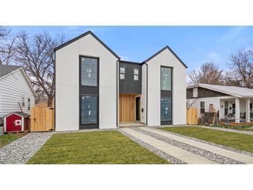 Striking modern home with black framed windows, white stucco, and a well manicured lawn with stone accents at 3049 S Cherokee St, Englewood, CO 80110