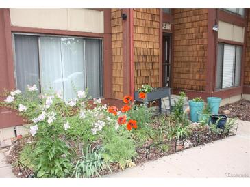 Charming home exterior with beautiful flowers and well-maintained landscaping at 1255 S Dillon Way, Aurora, CO 80012