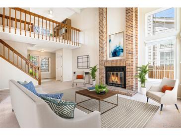 Bright living room boasts soaring ceilings, fireplace, and open floor plan at 1566 S Syracuse St, Denver, CO 80231