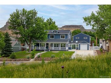 Charming two-story home with a welcoming front porch and well-maintained lawn, set against a scenic mountain backdrop at 2221 Illinois St, Golden, CO 80401