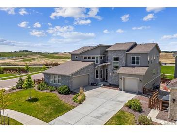Beautiful home showcasing stone accents, a three-car garage, and manicured landscaping at 8299 S Kellerman, Aurora, CO 80016