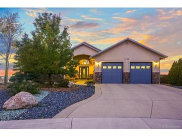 Charming home with a blue two-car garage, beautiful landscaping, and an inviting entrance at 1743 Homestead Dr, Fort Lupton, CO 80621