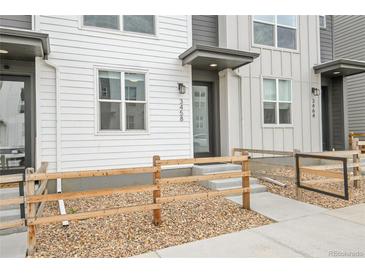 Charming townhome entrance featuring a covered doorway and attractive landscaping at 3458 W 63Rd Ave, Denver, CO 80221