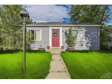 Charming bungalow with red door, well-manicured lawn, and walkway at 1164 Chester St, Aurora, CO 80010