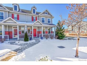 Two-story townhome with red front door and snow-covered yard at 14653 E Crestridge Dr, Centennial, CO 80015