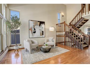 Bright living room with hardwood floors, a staircase, and comfortable seating at 722 S Eagle St, Aurora, CO 80012