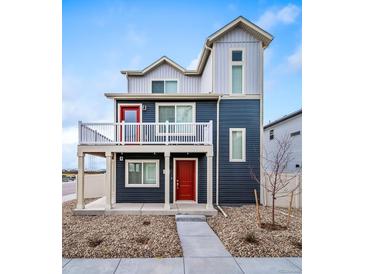 Stylish two-story home featuring a charming balcony, a red front door and low-maintenance landscaping at 13588 E 103Rd Pl, Commerce City, CO 80022