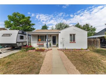 Charming home with a well-maintained front yard and camper parked in the driveway at 6751 Locust St, Commerce City, CO 80022