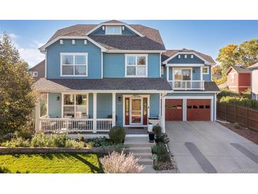 Charming two-story blue home featuring a welcoming front porch and attached two-car garage at 427 S Parkside Dr, Longmont, CO 80501