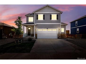Charming two-story home with a neutral gray exterior, neat landscaping, and attached two-car garage at 226 Racer St, Bennett, CO 80102