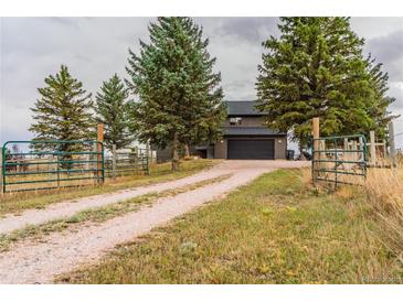 Charming two-story home featuring a spacious driveway, mature trees, and a two-car garage at 2312 Arabian Trl, Elizabeth, CO 80107