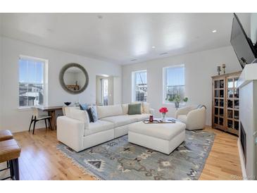 Bright living room features modern decor, hardwood floors, large windows and plush, comfortable seating arrangement at 4625 W 50Th Ave # 203, Denver, CO 80212