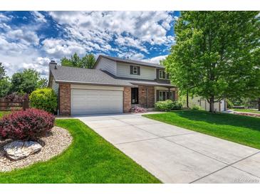 Charming two-story home with a well-manicured lawn and large driveway, perfect for Gathering living at 302 Northridge Rd, Highlands Ranch, CO 80126