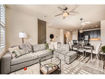 Bright living room featuring an open floor plan, hardwood floors, and a comfortable sectional sofa at 1817 S Buchanan Cir, Aurora, CO 80018