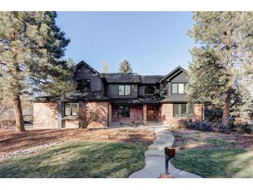Stunning two-story brick and dark siding home with mature trees and manicured lawn at 1 Winged Foot Way, Littleton, CO 80123