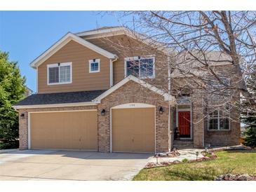 Charming two-story home featuring a three-car garage, brick accents, and manicured landscaping at 1122 Orion Way, Castle Rock, CO 80108