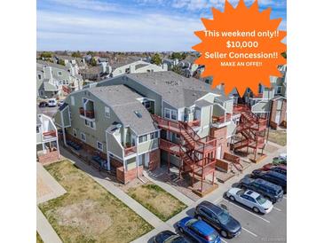 Inviting condo complex featuring ample parking, exterior stairways, and a well-maintained green space at 970 S Dawson Way # 15, Aurora, CO 80012