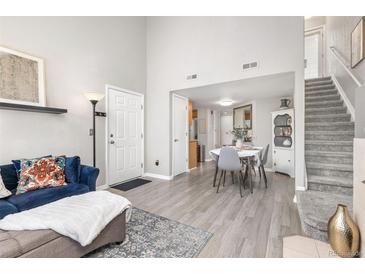 Inviting living room with hardwood floors, staircase, and abundant natural light creating a warm and welcoming atmosphere at 970 S Dawson Way # 15, Aurora, CO 80012