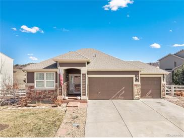 Charming single Gathering home with a three car garage, stone accents and neutral colored siding at 5238 Clearbrooke Ct, Castle Rock, CO 80104