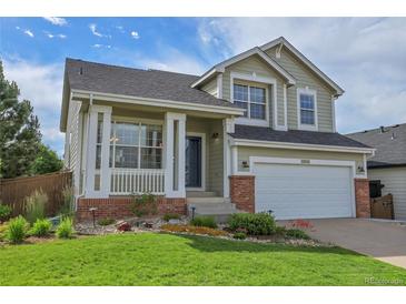 Charming two-story home with well-manicured lawn, covered porch, and attached two-car garage at 10115 Foxridge Ct, Highlands Ranch, CO 80126