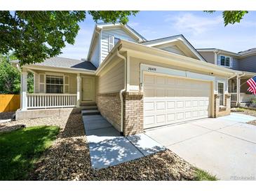 Charming home with a two-car garage, a well-kept lawn, and a inviting front porch at 20455 E Grand Ln, Aurora, CO 80015