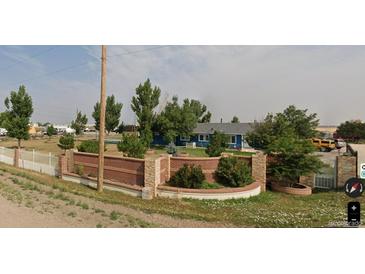 Ranch style home with brick wall and landscaped yard at 21861 E 26Th Ave, Aurora, CO 80019
