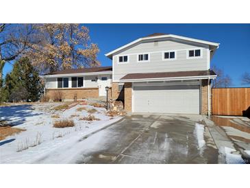 Charming two-story home with a two-car garage, brick accents and a well-manicured front yard at 8209 Balsam Way, Arvada, CO 80005