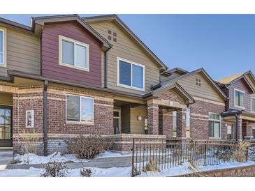 Brick townhouse exterior with a small front yard and metal fence at 6448 Silver Mesa Dr # B, Highlands Ranch, CO 80130