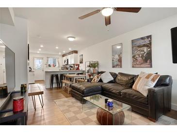 Inviting living room with a large sectional couch, open to the kitchen, creating a seamless living space at 4820 W 13 Ave, Denver, CO 80204