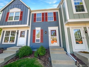 Charming townhome featuring colorful siding, red shutters, and a well-maintained front yard at 960 Milo Cir # B, Lafayette, CO 80026