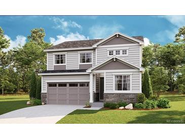 Charming two-story home with gray siding, stone accents, manicured lawn, and attached two car garage at 1431 Lumber Ridge N Cir, Erie, CO 80516