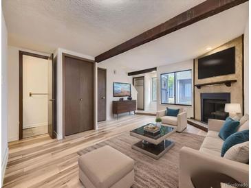 Inviting living room with a fireplace, wood beams, and stylish furnishings at 2949 Shady Holw, Boulder, CO 80304