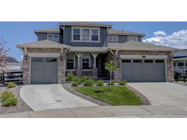 Charming two-story home with a stone and siding exterior, three-car garage, and well-manicured front yard at 22593 E Piccolo Way, Aurora, CO 80016