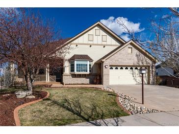 Charming home featuring a manicured lawn, brick accents, and a convenient two-car garage at 8198 S Sicily Ct, Aurora, CO 80016