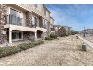 Attractive multi-story townhome with stone accents and well-maintained landscaping at 14902 E Poundstone Dr, Aurora, CO 80015