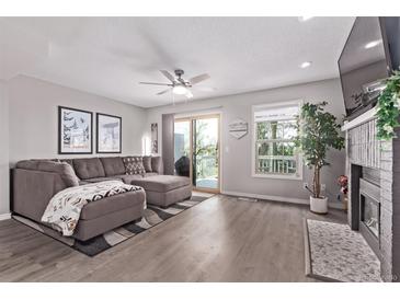 Inviting living room featuring a comfortable sectional sofa, fireplace, and sliding glass doors to a deck at 12183 W Chenango Dr, Morrison, CO 80465