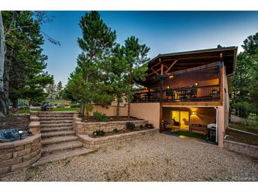 Inviting outdoor living space with a large patio, and steps leading to upper yard at dusk at 1059 S Elbert St, Elizabeth, CO 80107