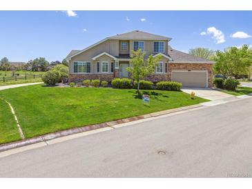 Charming two-story home with lush front lawn, mature landscaping, and a two-car garage at 22455 E Plymouth Cir, Aurora, CO 80016