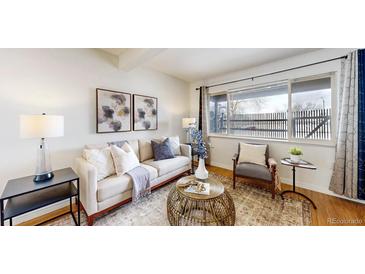 Bright living room featuring a comfortable sofa, stylish decor, and large windows at 3663 S Sheridan Blvd # P1, Denver, CO 80235