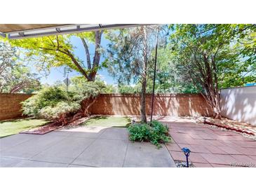 Private backyard patio featuring brick walls, mature trees, and a well-maintained landscape at 2500 S York St # 116, Denver, CO 80210