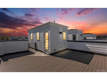 A rooftop deck with composite planks and a small building offers a private outdoor space with sunset views at 888 S Valentia St # 101, Denver, CO 80247