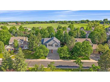 Charming two-story home with a well-manicured lawn and mature trees at 5746 Aspen Creek Dr, Broomfield, CO 80020